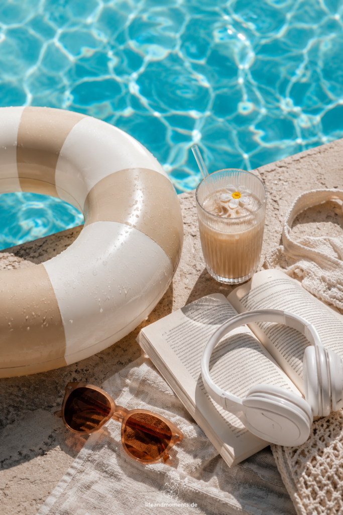 Pool mit Schwimmreifen und Getränk und Kopfhörern